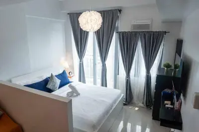 a bedroom with a bed and a large window at The Hmlet Manila, Near Poblacion Makati Nightlife in Manila