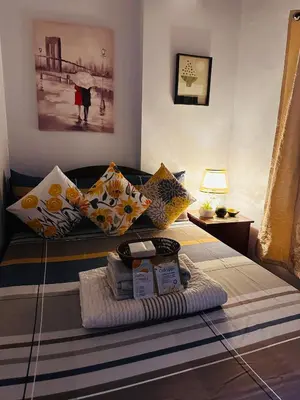 a living room with a couch with pillows at Isabelle Garden Villas Condominium Paranaque City in Manila