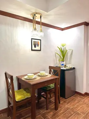 a dining room with a table and chairs and a refrigerator at Isabelle Garden Villas Condominium Paranaque City in Manila