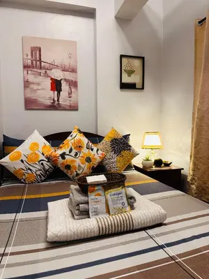a pile of pillows and towels on a bed at Isabelle Garden Villas Condominium Paranaque City in Manila