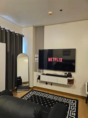 a living room with a television on a wall at Harmony Suite Hope Trece Cavite in Trece Martires