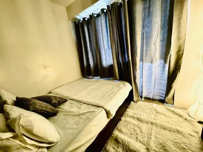 a small room with two beds and a window at Beach Haven Condo in MOAs Shore Resort near Okada City of Dreams Solaire in Manila