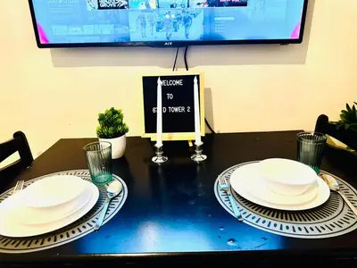 two white plates on a table with a tv at Beach Haven Condo in MOAs Shore Resort near Okada City of Dreams Solaire in Manila