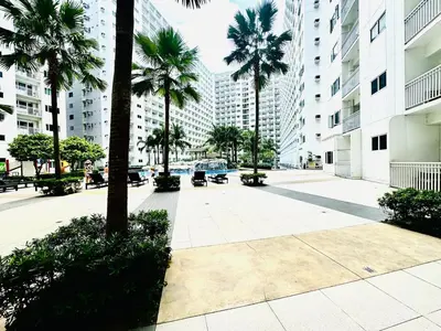 a courtyard in a city with palm trees and buildings at Beach Haven Condo in MOAs Shore Resort near Okada City of Dreams Solaire in Manila