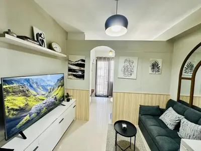 a living room with a couch and a flat screen tv at Peaceful Nest at Shore 2 Res in Manila