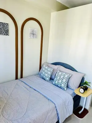a bedroom with a bed with a blue comforter and pillows at Peaceful Nest at Shore 2 Res in Manila