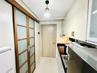 a kitchen with a wooden door and a hallway at Peaceful Nest at Shore 2 Res in Manila