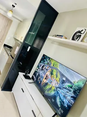 a large flat screen tv sitting on top of a kitchen counter at Peaceful Nest at Shore 2 Res in Manila