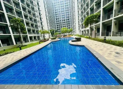 a blue swimming pool in a building with tall buildings at Peaceful Nest at Shore 2 Res in Manila