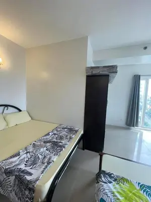 a small bedroom with a bed and a window at Shell Residence in Manila