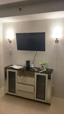 a desk with a flat screen tv on a wall at Shell Residence in Manila