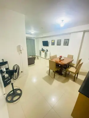 a living room with a table and chairs and a camera at Shell Residence in Manila