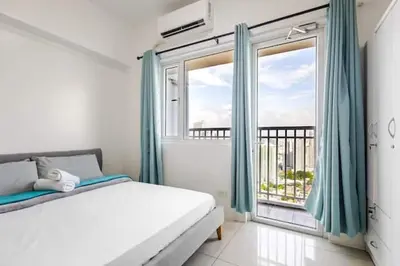 a bedroom with a bed and a large window at Sunrise & City View Steps from MOA & Bay Free WiFi in Manila
