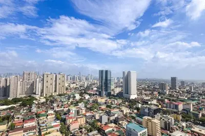 a city with tall buildings and a blue sky at Sunrise & City View Steps from MOA & Bay Free WiFi in Manila