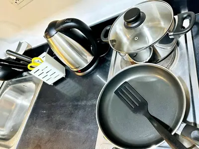a frying pan with a spatula on a stove at CL10100 House in Manila