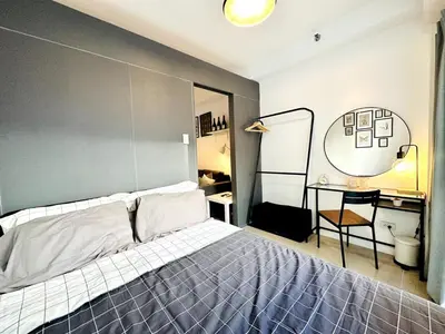 a bedroom with a bed and a desk and a mirror at CL10100 House in Manila
