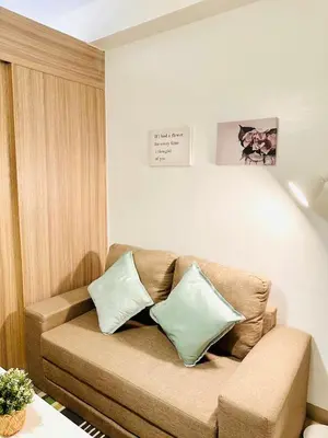 a living room with a brown couch with two pillows at CB 1162 House in Manila
