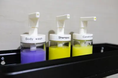 a black shelf with three different colored liquids at CB 1162 House in Manila