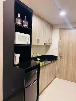 a kitchen with a black refrigerator and a sink at JCS Place in Manila