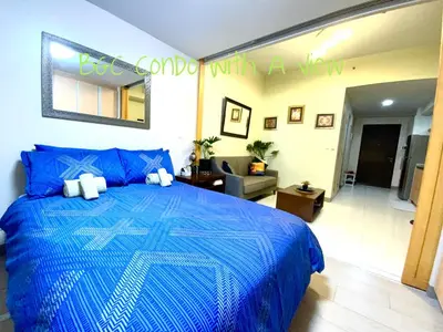a bedroom with a blue bed with a blue comforter at BGC One Uptown in Manila
