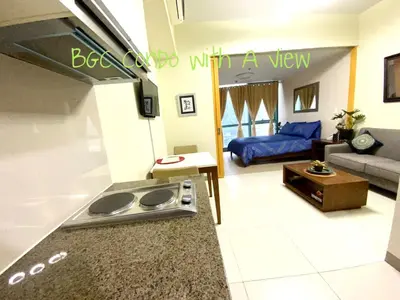 a kitchen with a stove and a couch in a room at BGC One Uptown in Manila