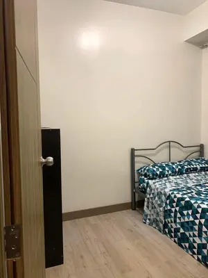 a bedroom with a bed next to a door at Ohana Residences by SMDC in Manila
