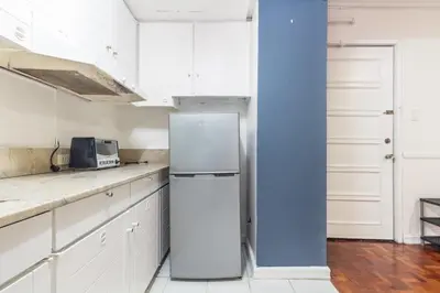 a kitchen with a refrigerator and a blue wall at Stylish Hip studio in the Heart of Poblacion, in Manila