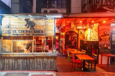a restaurant with tables and chairs in front of it at Stylish Hip studio in the Heart of Poblacion, in Manila