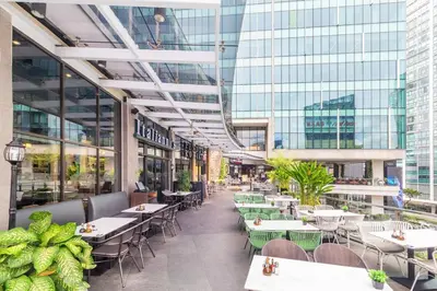 a restaurant with tables and chairs in a building at Stylish condo in BGC near Uptown mall and St Lukes in Manila