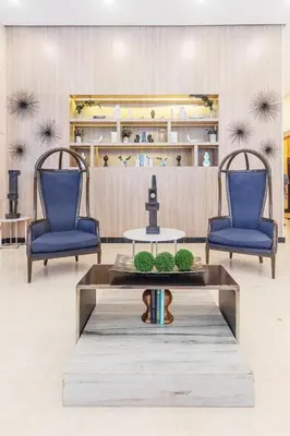 a lobby with two blue chairs and a table at Stylish condo in BGC near Uptown mall and St Lukes in Manila