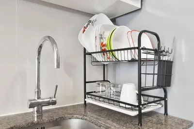a shelf over a sink with plates on it at Stylish condo in BGC near Uptown mall and St Lukes in Manila