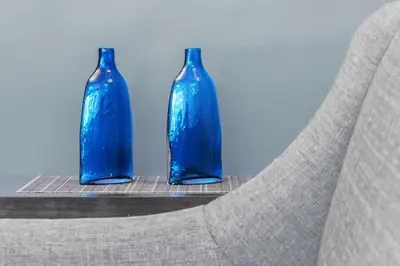 two blue bottles sitting on top of a chair at Stylish condo in BGC near Uptown mall and St Lukes in Manila