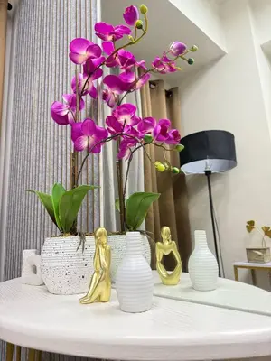 a white table with vases and purple flowers on it at LNicoles Pad in Manila