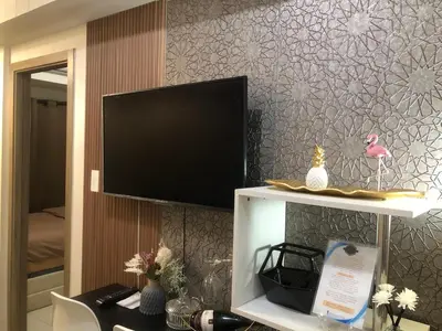 a living room with a tv and a desk with a desk at LNicoles Pad in Manila