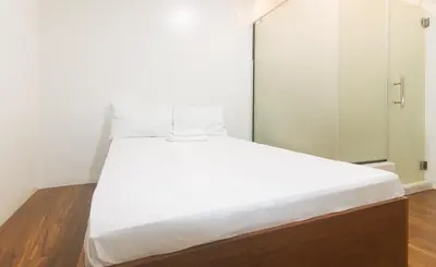a bed with white sheets and pillows in a room at GREN PLACE near Baclaran Airport Road by RedDoorz in Manila