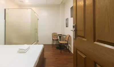 a room with a bed and a table with chairs at GREN PLACE near Baclaran Airport Road by RedDoorz in Manila
