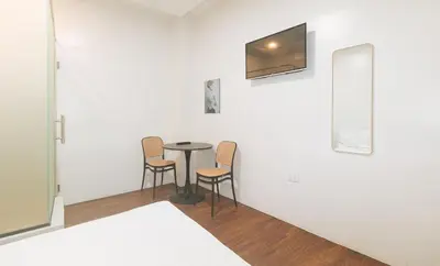 a table in a room with two chairs and a mirror at GREN PLACE near Baclaran Airport Road by RedDoorz in Manila