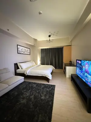a hotel room with a bed and a flat screen tv at 81 Newport Blvd Cluster 5 Unit 3F by Rechelle Nunag in Manila