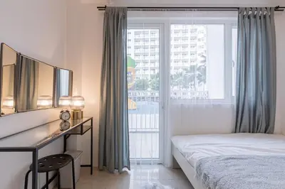 a bedroom with a bed and a desk and a window at BD281 House in Manila