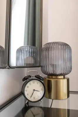 a clock on a table next to two mirrors at BD281 House in Manila