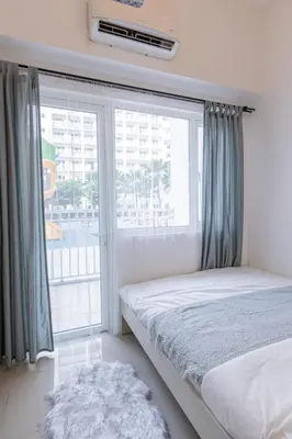 a bedroom with a bed and a large window at BD281 House in Manila