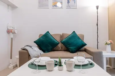 a living room with a couch with green pillows at BD281 House in Manila
