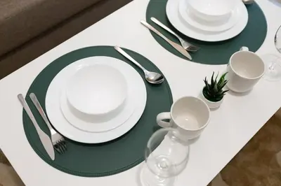 a white table with green plates and silverware on it at BD281 House in Manila