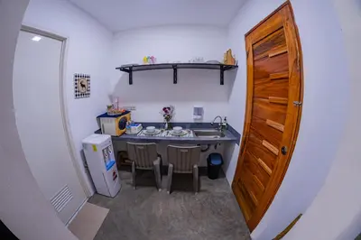 a small kitchen with a table and a refrigerator at Sotera and Paz Forestville in Silang