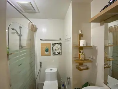 a white bathroom with a shower and a toilet at South of Market Private Residences nr SM Aura BGC in Manila