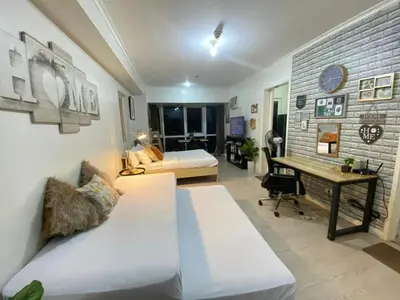 a bedroom with a bed and a desk in a room at South of Market Private Residences nr SM Aura BGC in Manila