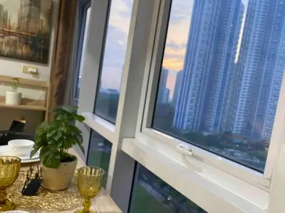 a room with a window with a view of a city at South of Market Private Residences nr SM Aura BGC in Manila