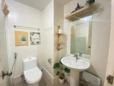 a white bathroom with a toilet and a sink at South of Market Private Residences nr SM Aura BGC in Manila