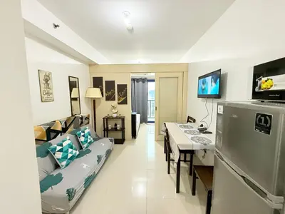 a living room with a couch and a table at Sea Residences MoaPasay City By Jerson in Manila
