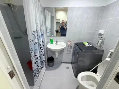 a man taking a picture of a bathroom with a toilet and sink at Sea Residences MoaPasay City By Jerson in Manila